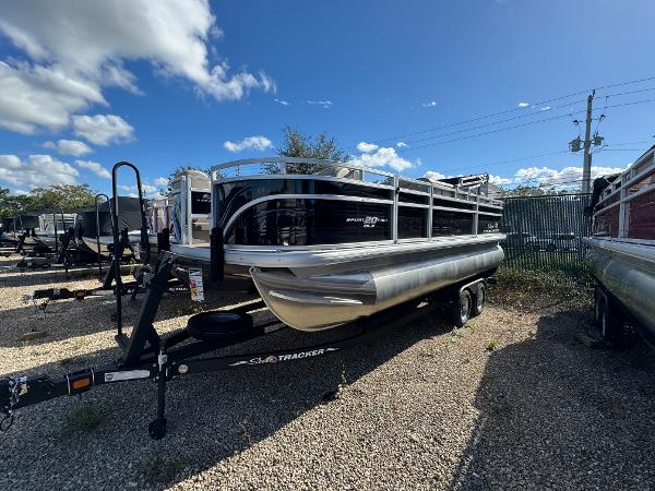 Sun Tracker SportFish 20 DLX 2024 Sun Tracker SportFish 20 DLX pontoon boat on trailer, parked outdoors.
