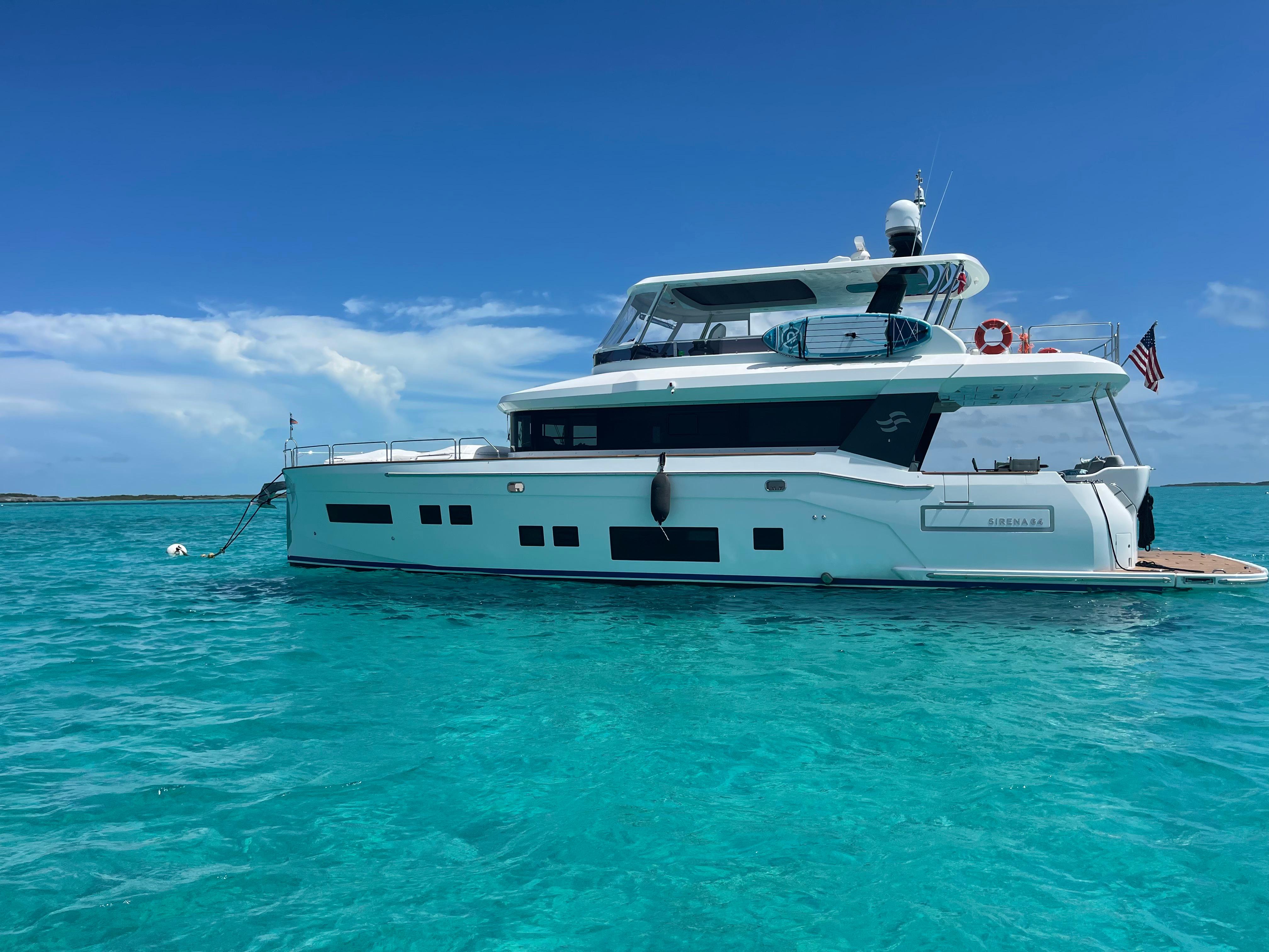 Sirena 64 Luxury Sirena 64 yacht from 2020 on turquoise waters under clear blue sky.