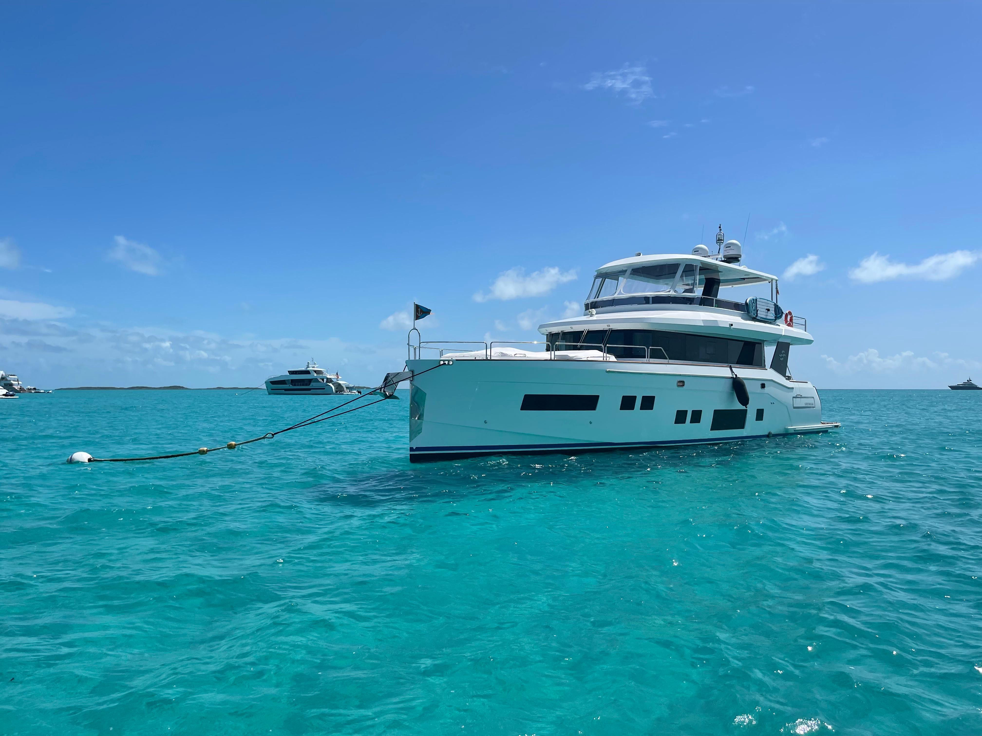 Sirena 64 Luxurious 2020 Sirena 64 yacht anchored in clear turquoise waters under a bright blue sky.