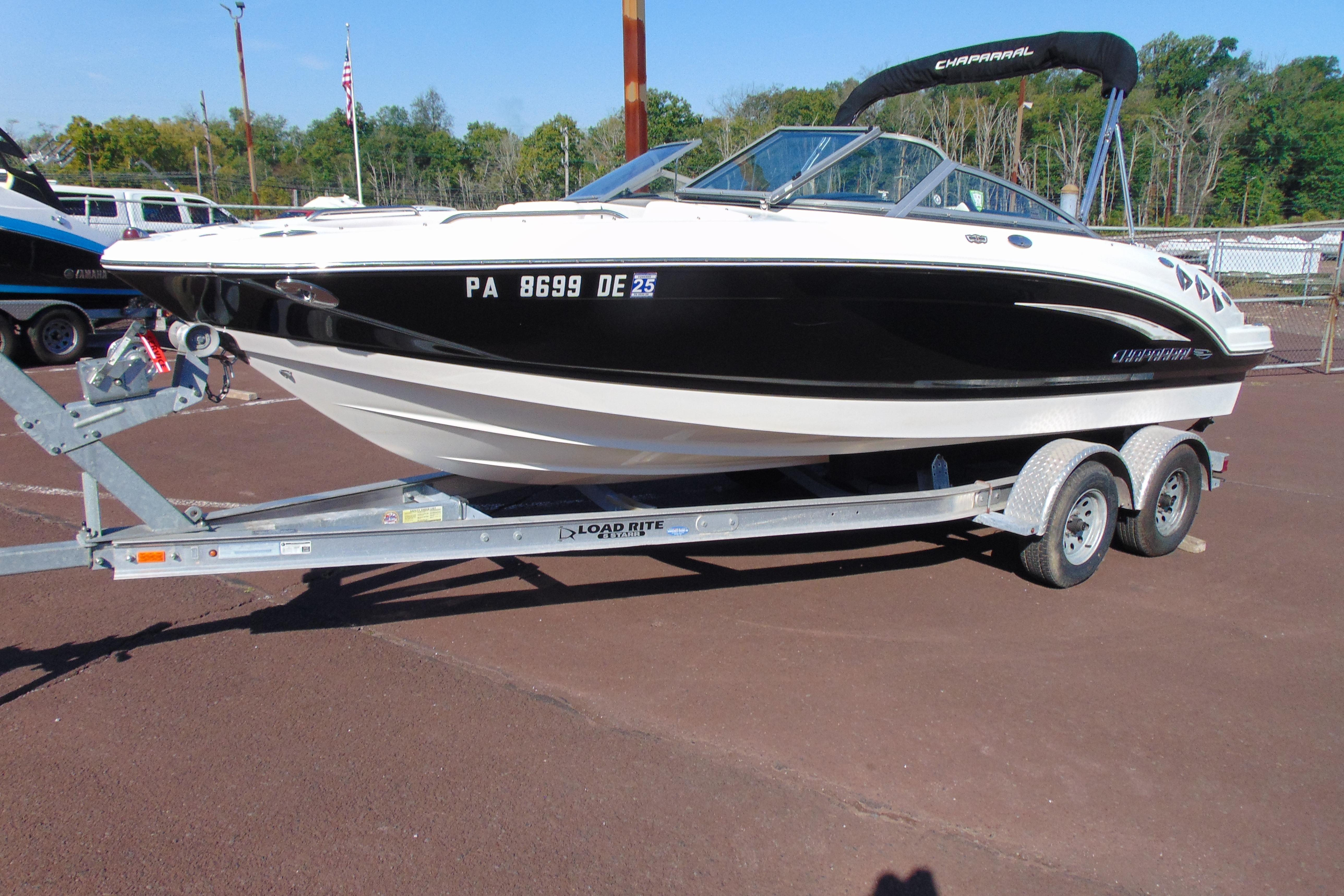 Chaparral 216 SSi 2010 Chaparral 216 SSi boat on trailer, black and white design, parked outdoors.