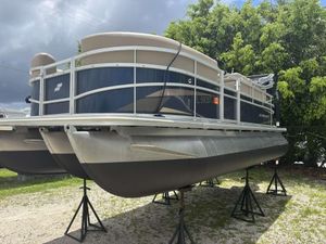 Starcraft LX 20 R 2022 Starcraft LX 20 R pontoon boat on stands, under cloudy sky.