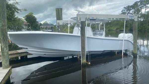 Yellowfin 32 2022 Yellowfin 32 boat on lift, docked by a calm waterfront.
