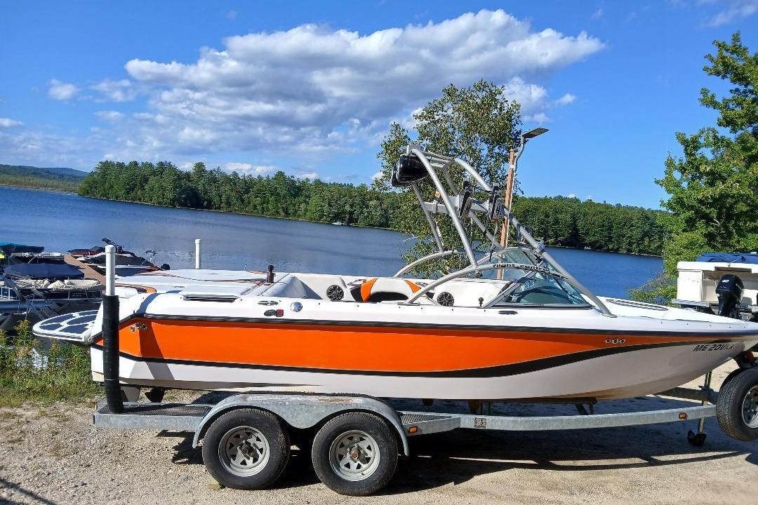 Correct Craft Super Air Nautique 2004 Correct Craft Super Air Nautique boat on trailer by a scenic lake.