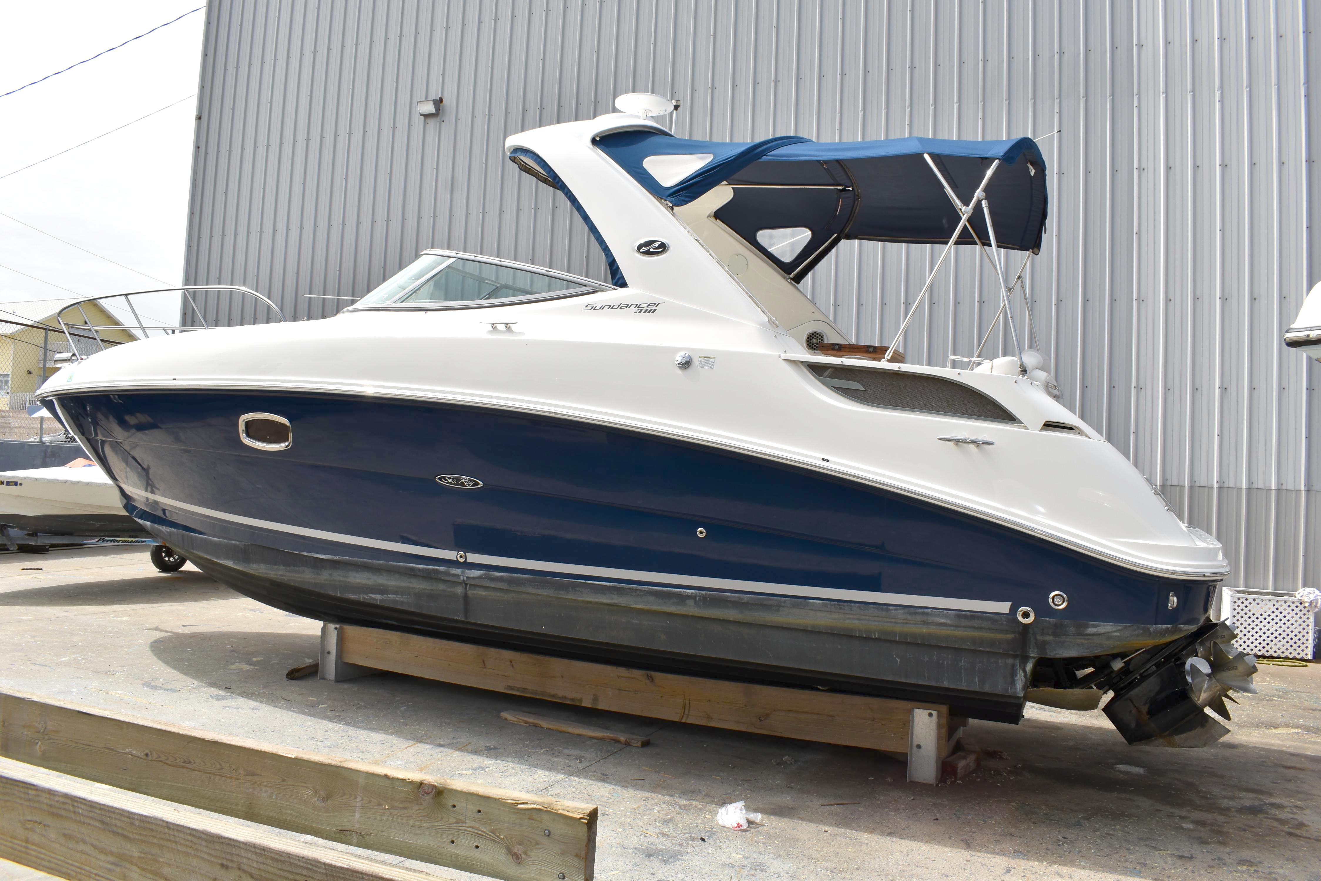 Sea Ray 310 Sundancer 2011 Sea Ray 310 Sundancer boat with blue hull and white top, docked outdoors.