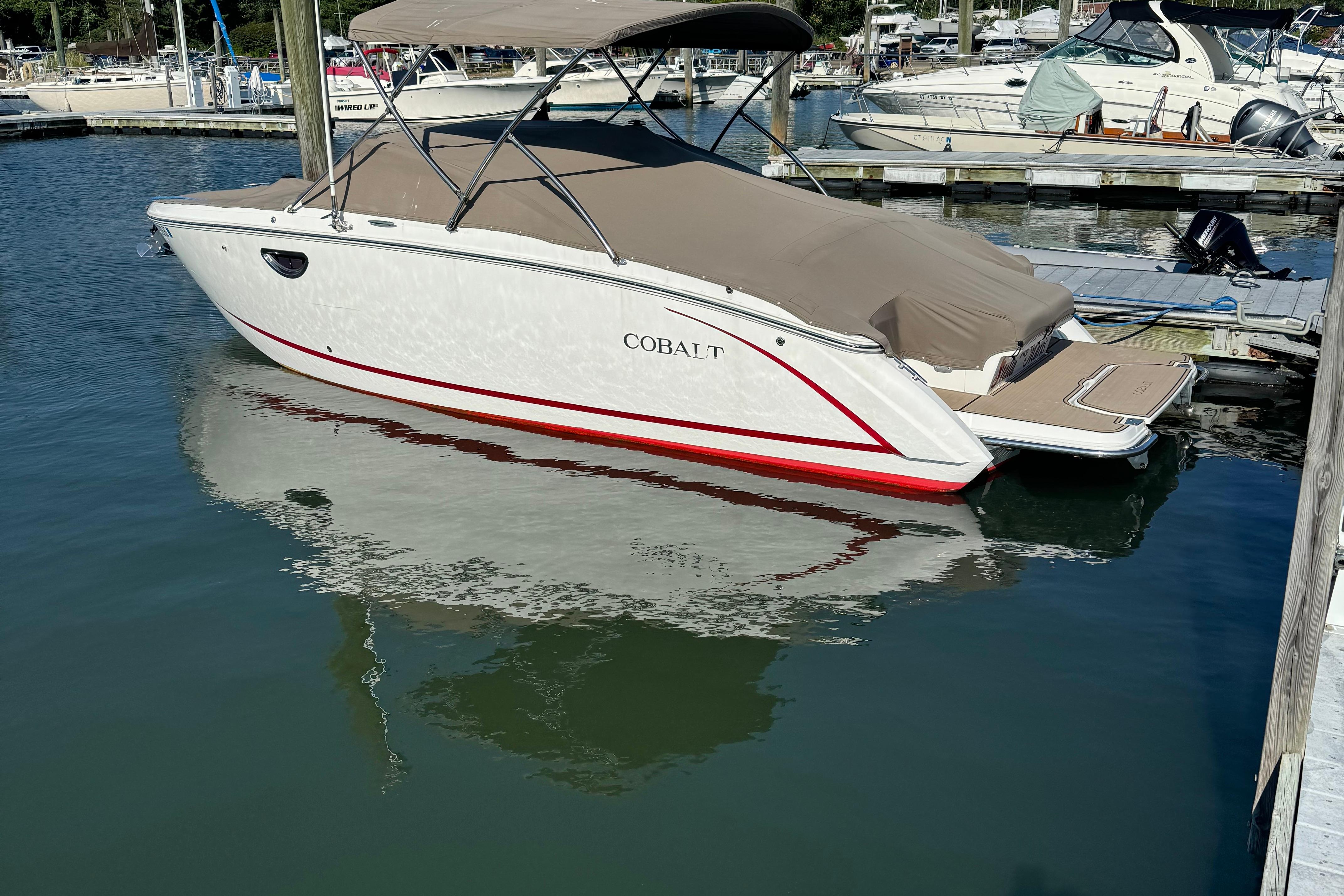 Cobalt R5 2014 Cobalt R5 boat docked in marina, covered with beige canopy.