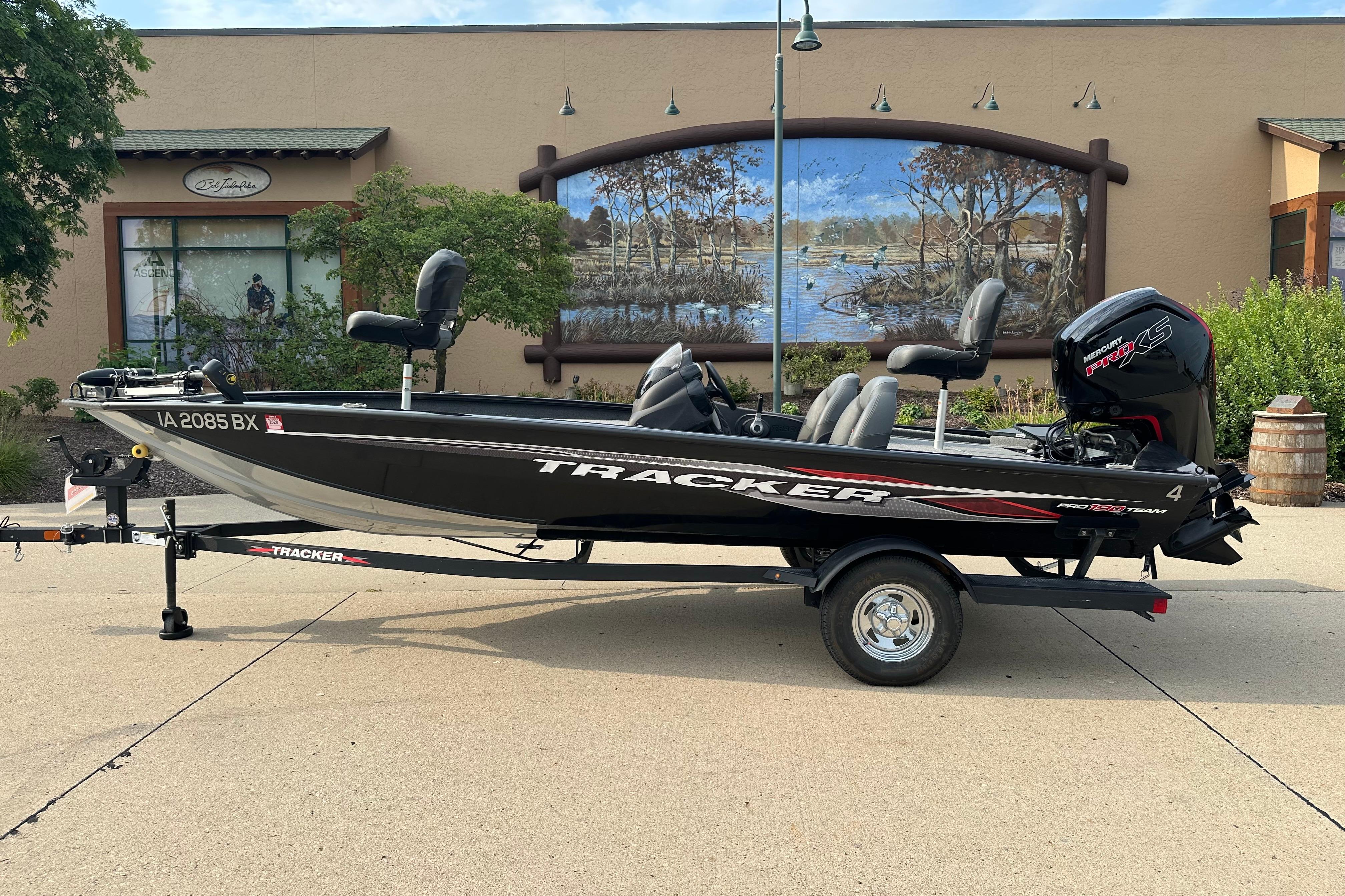 Tracker Pro Team 190 TX 2024 Tracker Pro Team 190 TX boat on trailer, parked outdoors near a mural.