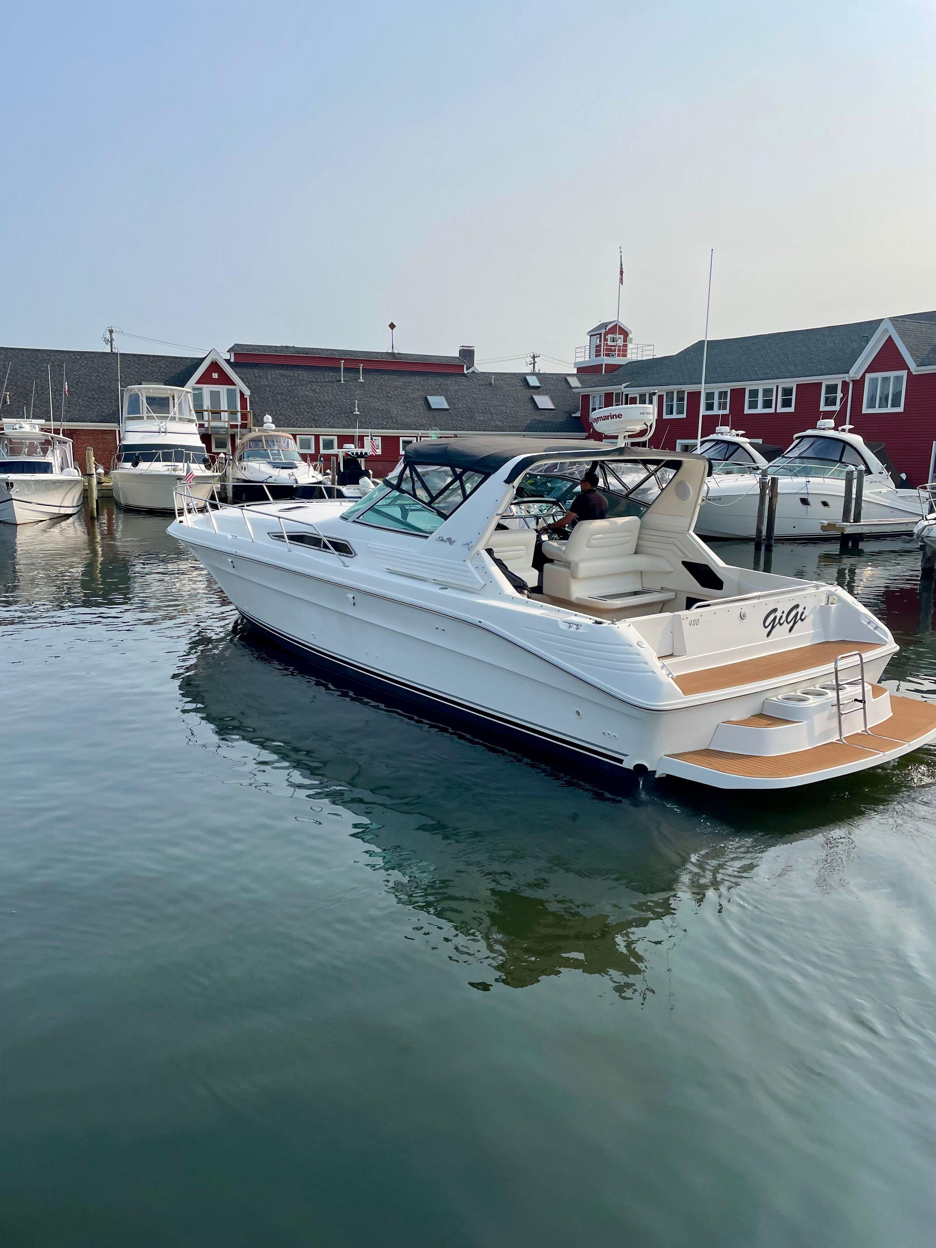 Sea Ray 400 Express Cruiser 1992 Sea Ray 400 Express Cruiser docked at marina, calm water, red buildings in background.