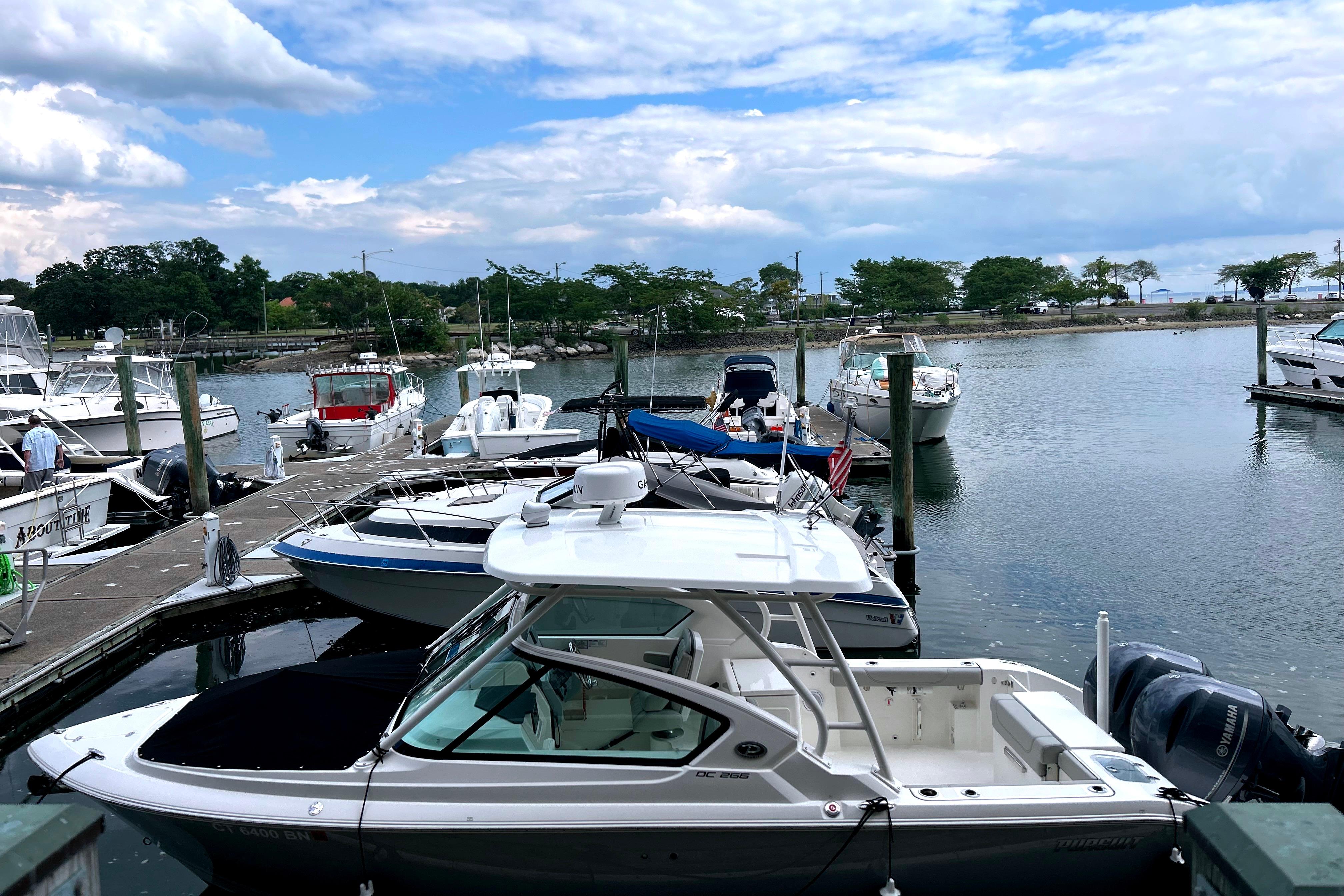 Pursuit DC 266 Dual Console 2023 Pursuit DC 266 Dual Console boat docked in a scenic marina.