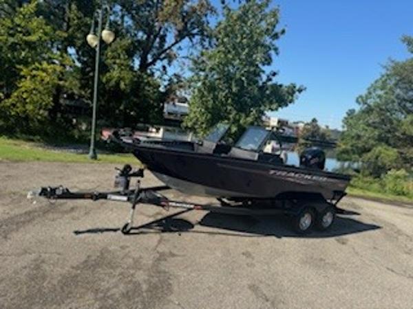 Tracker Pro Guide V-175 WT 2024 Tracker Pro Guide V-175 WT boat on trailer, parked outdoors near trees and water.