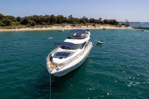 Sunseeker Manhattan 74 Luxury Sunseeker Manhattan 74 yacht anchored near a scenic beach, 2001 model.
