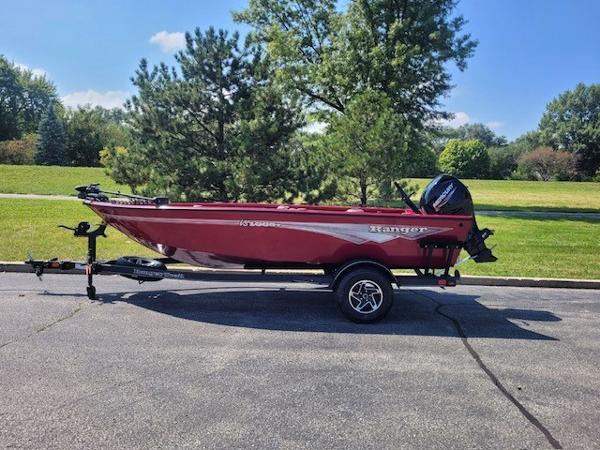 Ranger VS1665T 2024 Ranger VS1665T boat on trailer, parked outdoors, surrounded by greenery.