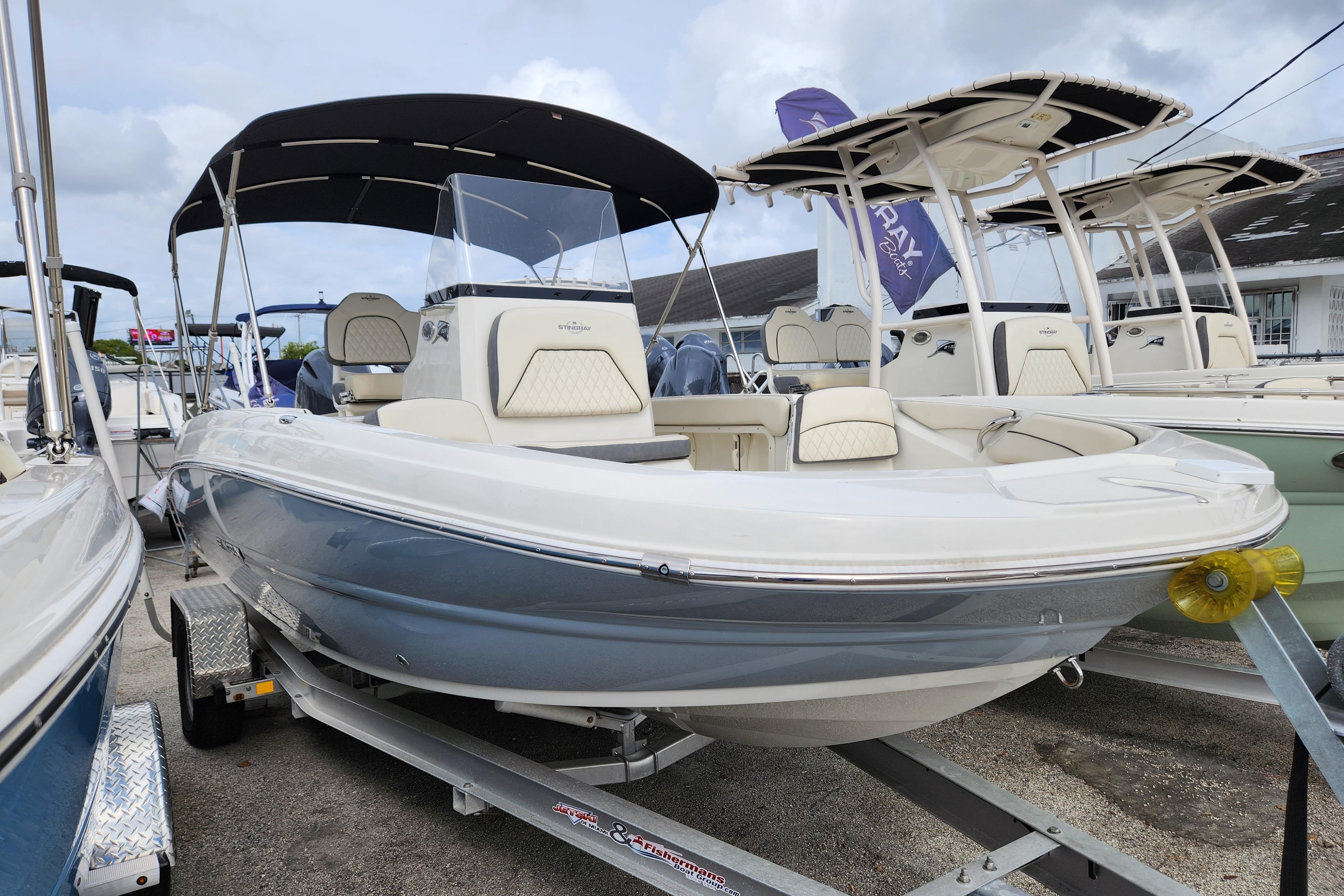 Stingray 206cc 2023 Stingray 206cc boat with canopy on trailer, displayed at a dealership.
