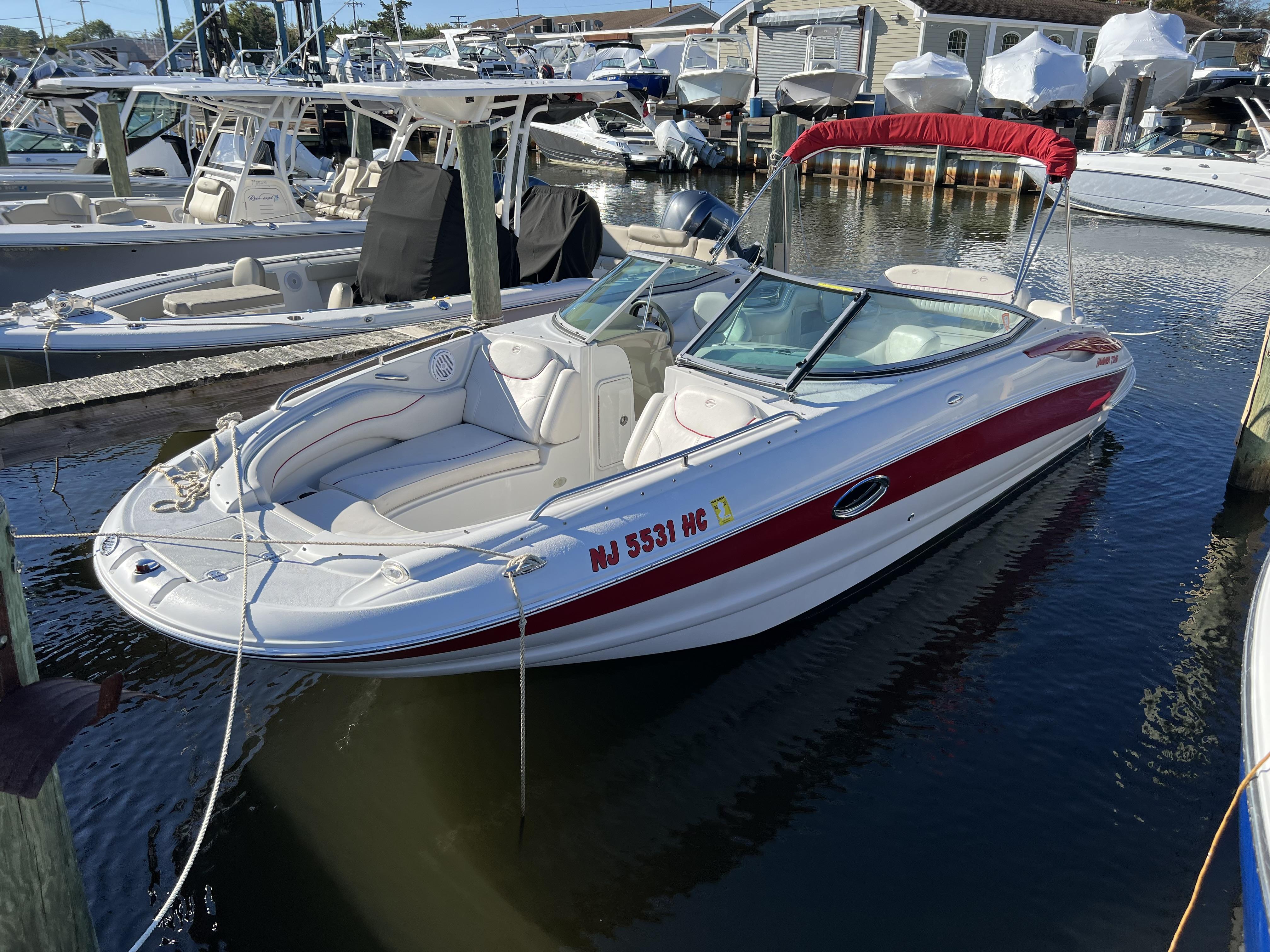 Crownline 240 EX 2008 Crownline 240 EX boat docked in a marina with red and white exterior.