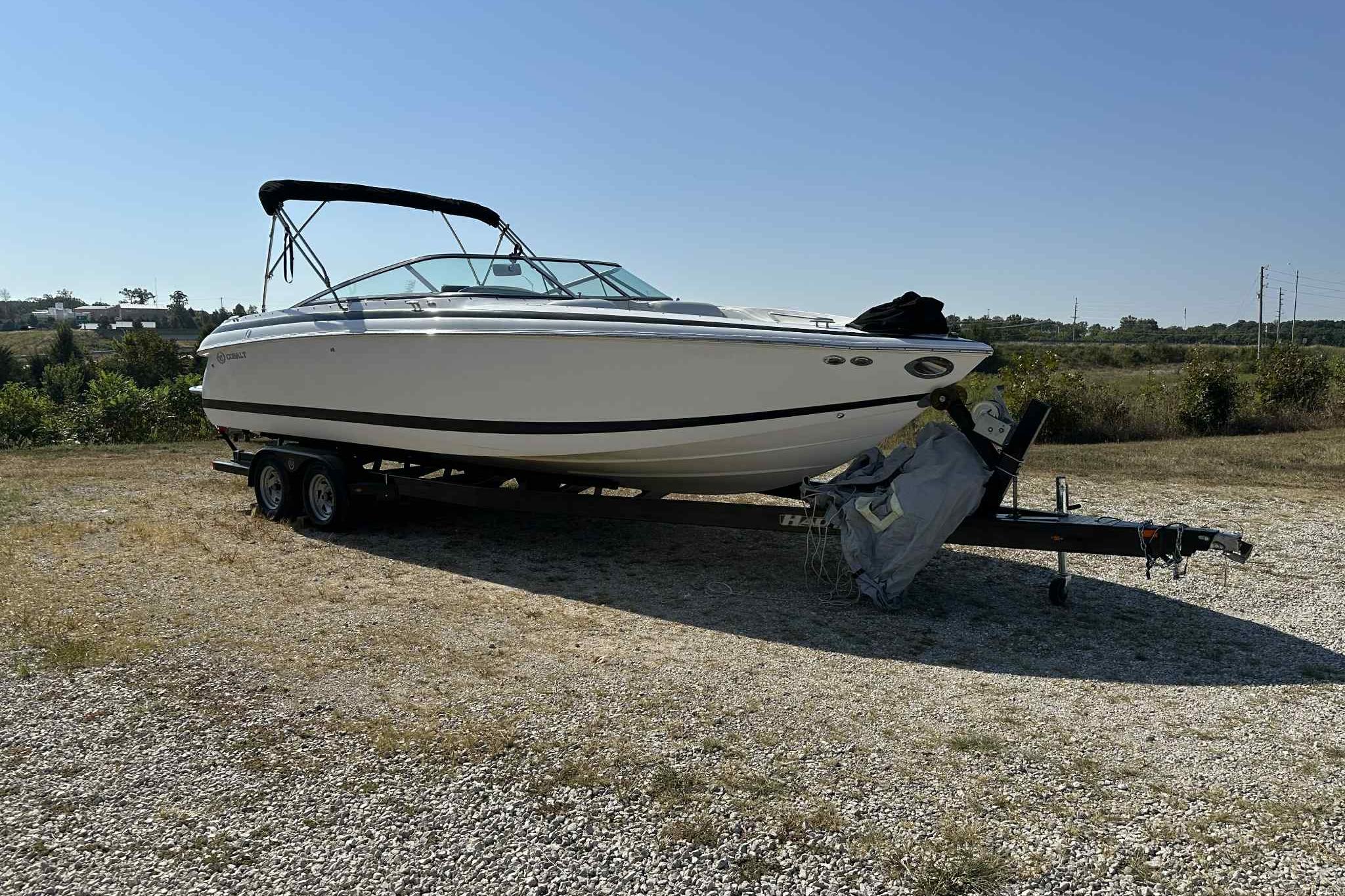 Cobalt 262 2005 Cobalt 262 boat on trailer in a grassy area under clear sky.