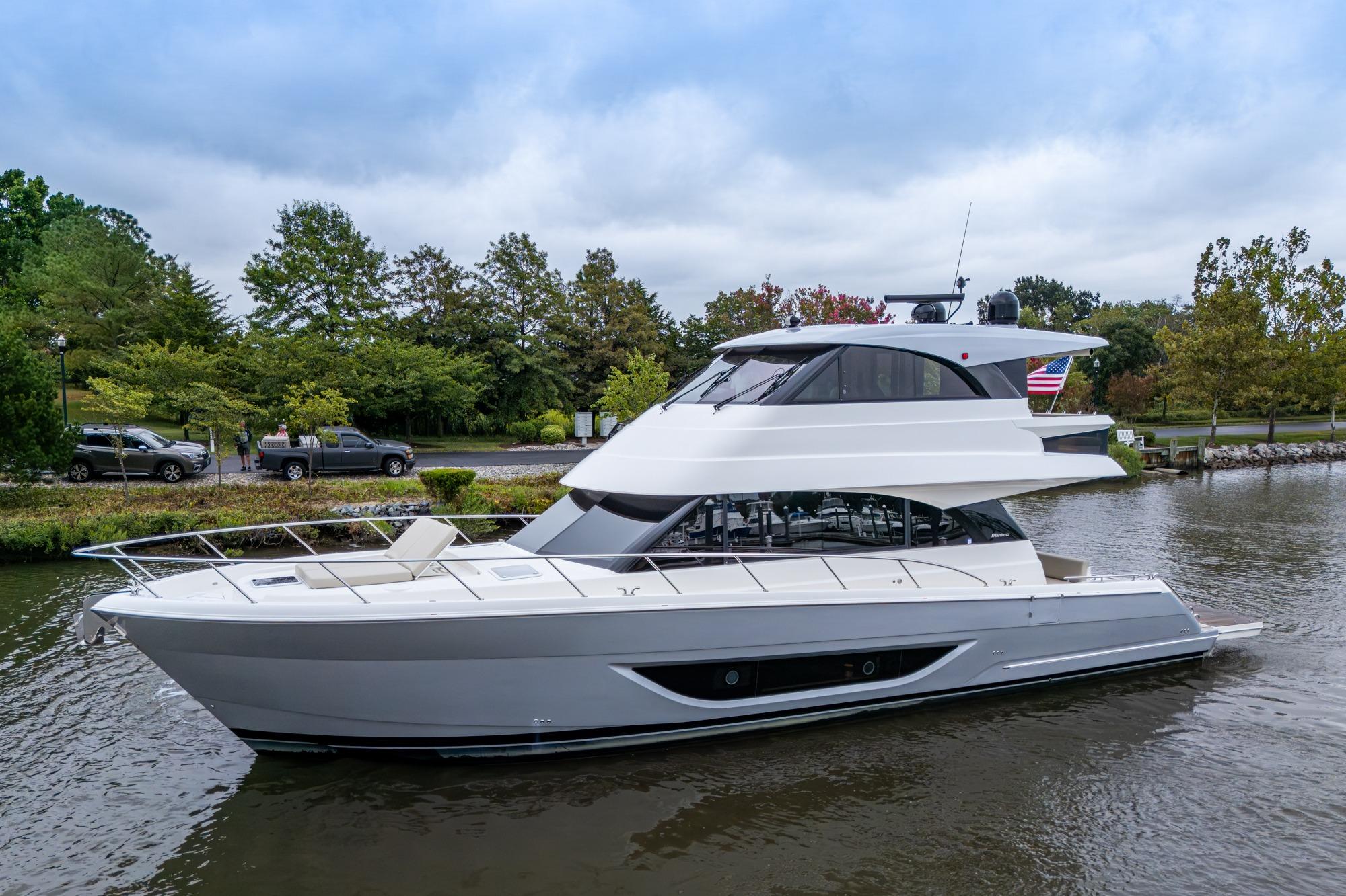 Maritimo M55 2023 Maritimo M55 yacht on a serene river with lush greenery.