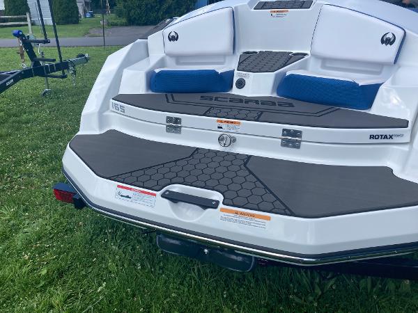 Scarab 165 2024 Scarab 165 boat rear view with Rotax engine on grass.