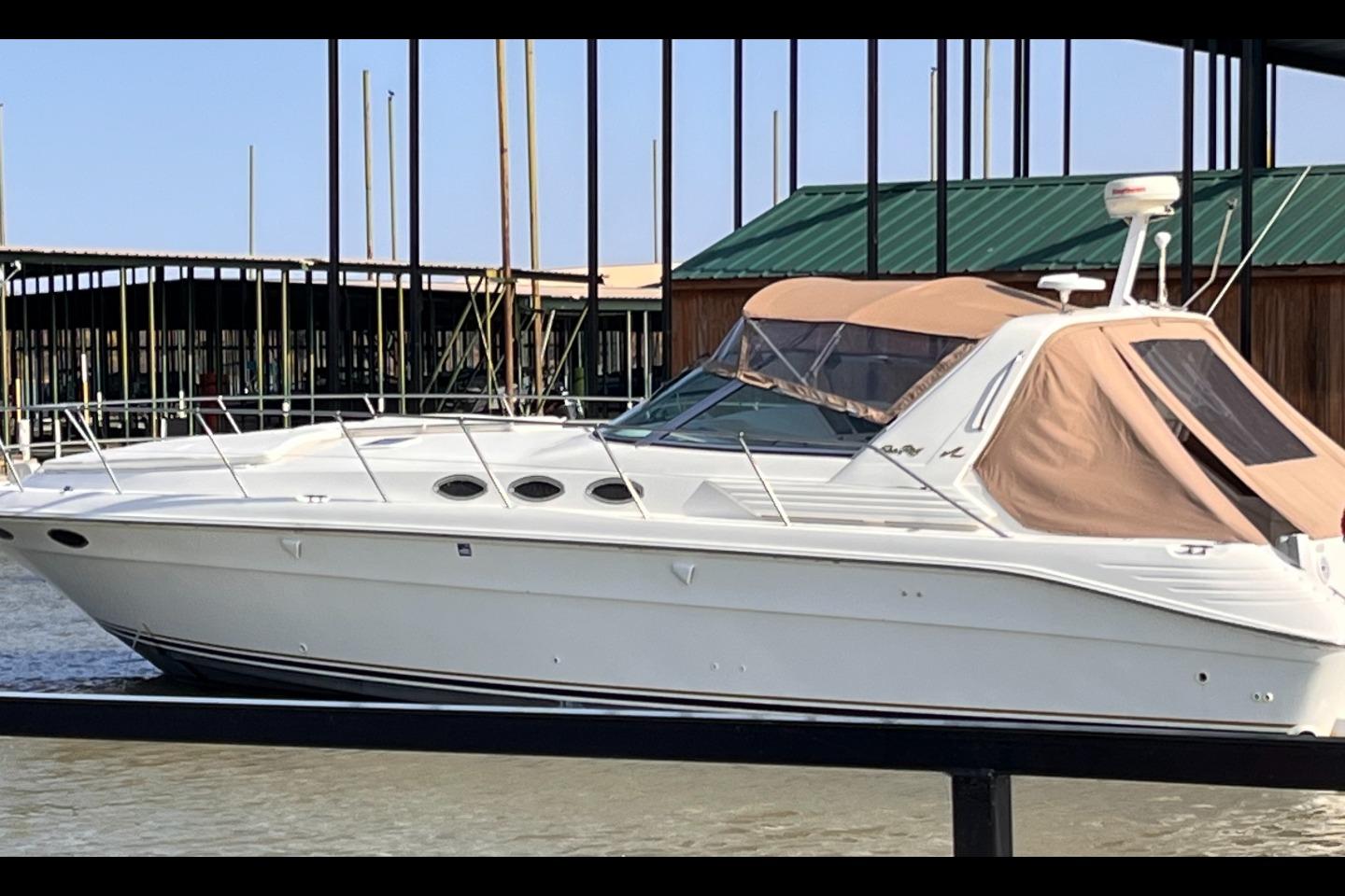 Sea Ray 400 Express Cruiser 1996 Sea Ray 400 Express Cruiser docked at marina, featuring sleek white design and tan canopy.