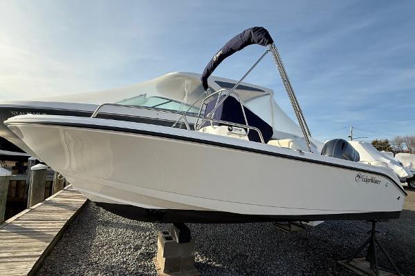 Edgewater 170CC 2023 Edgewater 170CC boat on display at a marina, featuring sleek design and bimini top.