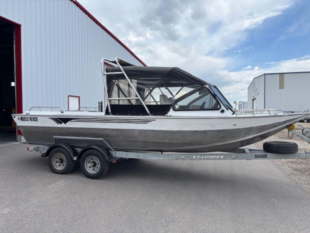 North River 21 jet 2002 North River 21 Jet boat on trailer, parked outside a large building.