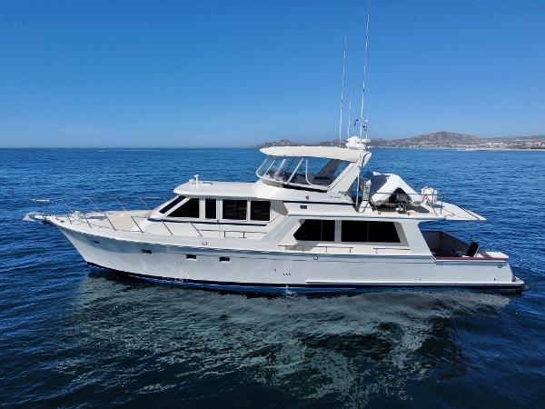 Offshore Yachts 62 Pilothouse 2000 Offshore Yachts 62 Pilothouse cruising on open sea under clear blue sky.