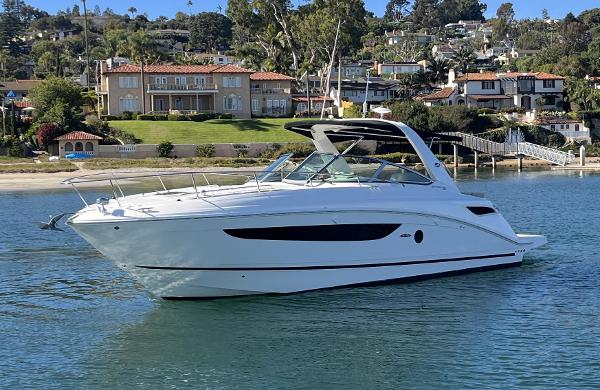 Sea Ray 350 Sundancer 2014 Sea Ray 350 Sundancer yacht cruising near waterfront homes.