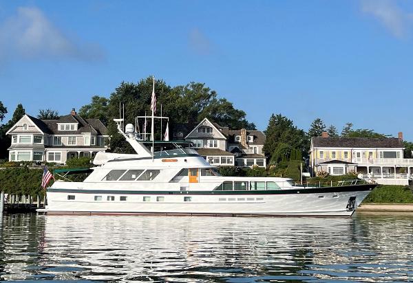 Burger 91 Luxury yacht Burger 91, 1984 model, docked near elegant waterfront homes.