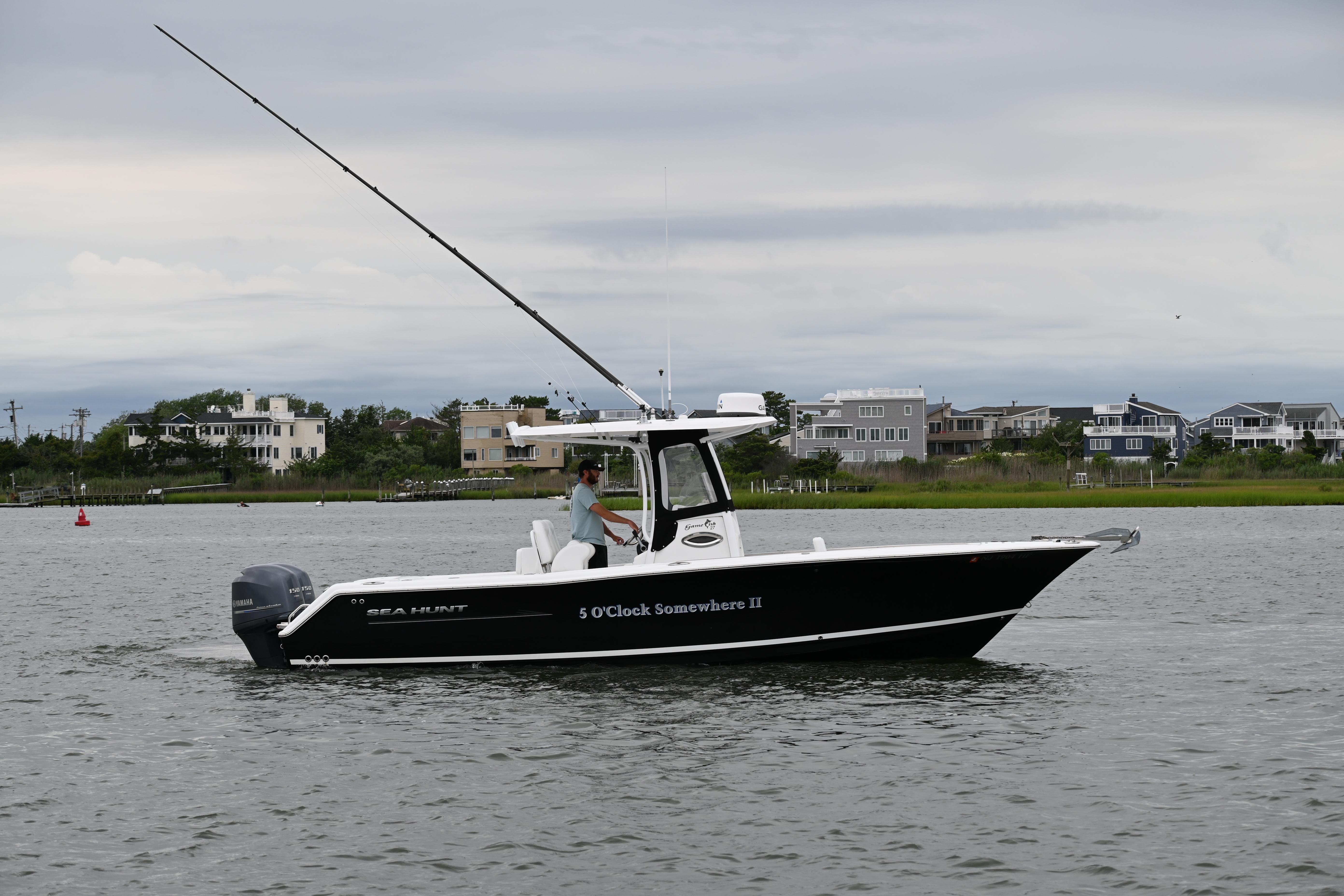Sea Hunt Gamefish 27 2013 Sea Hunt Gamefish 27 boat on water, overcast sky, coastal homes in background.