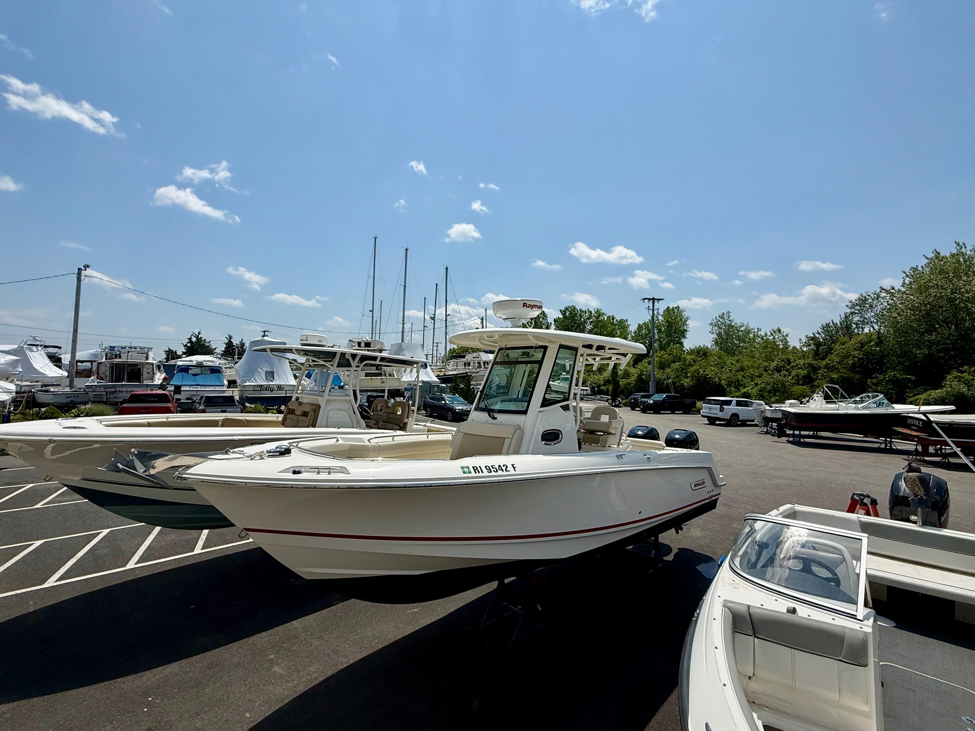 Boston Whaler 250 Outrage 2017 Boston Whaler 250 Outrage boat parked in a marina under a clear blue sky.