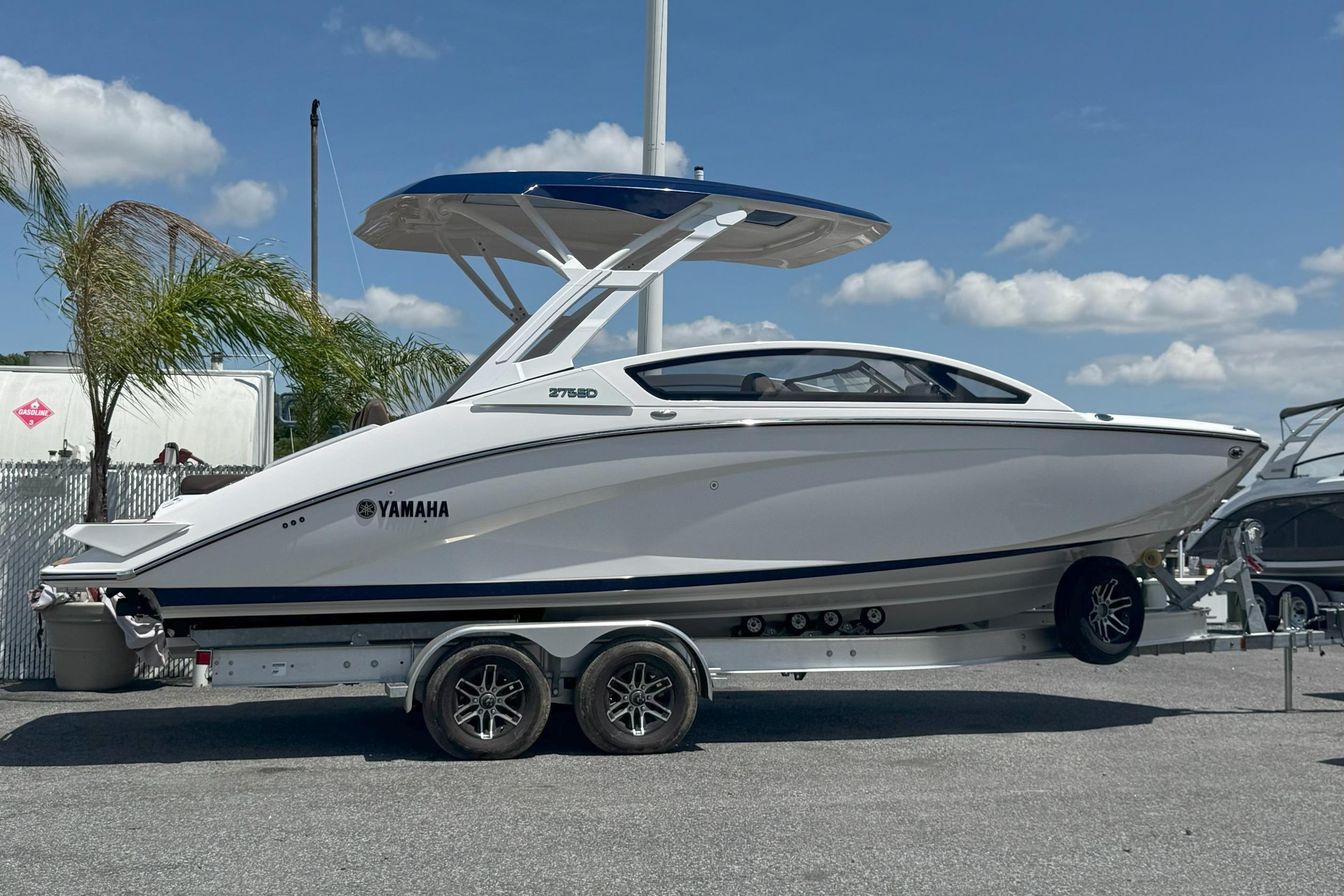 Yamaha Boats 275SD 2025 Yamaha Boats 275SD on trailer, sleek design, parked outdoors under blue sky.