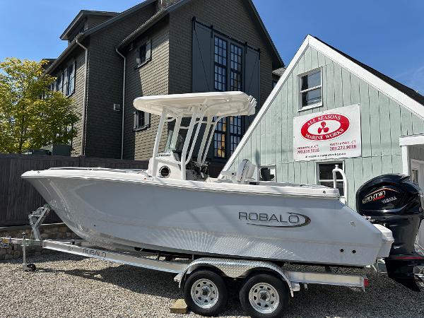 Robalo R230 Center Console 2025 Robalo R230 Center Console boat on trailer, parked near buildings.