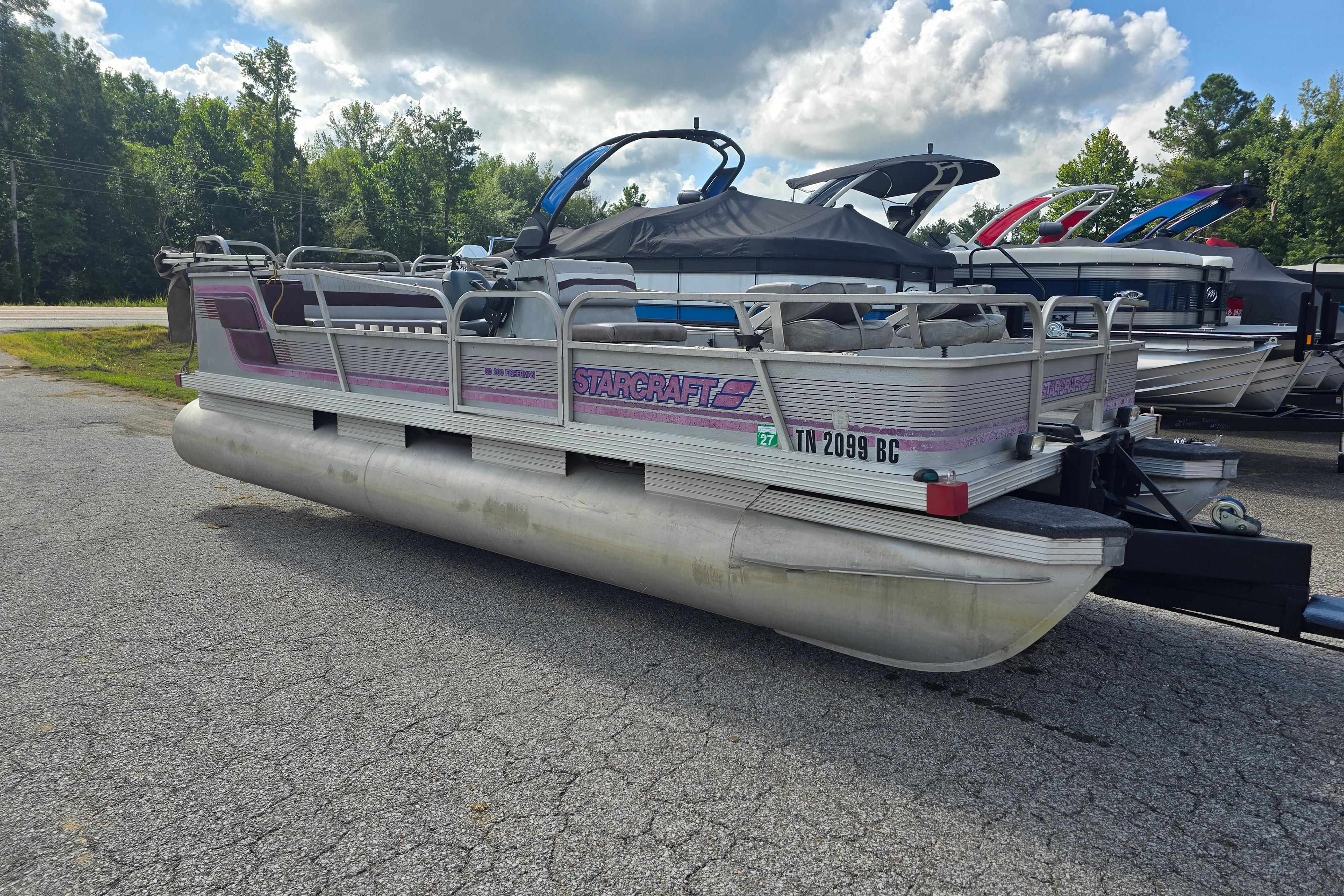 Starcraft SD200 1988 Starcraft SD200 pontoon boat parked on asphalt with trees in the background.