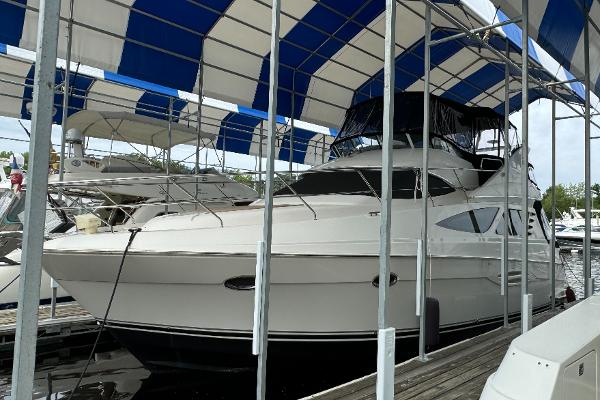 Silverton 43 Sport Bridge 2006 Silverton 43 Sport Bridge yacht docked under blue and white canopy.