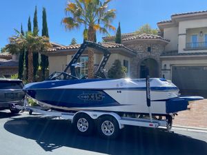 Axis Wake Research 2016 Axis Wake Research boat on trailer in front of a luxury house.