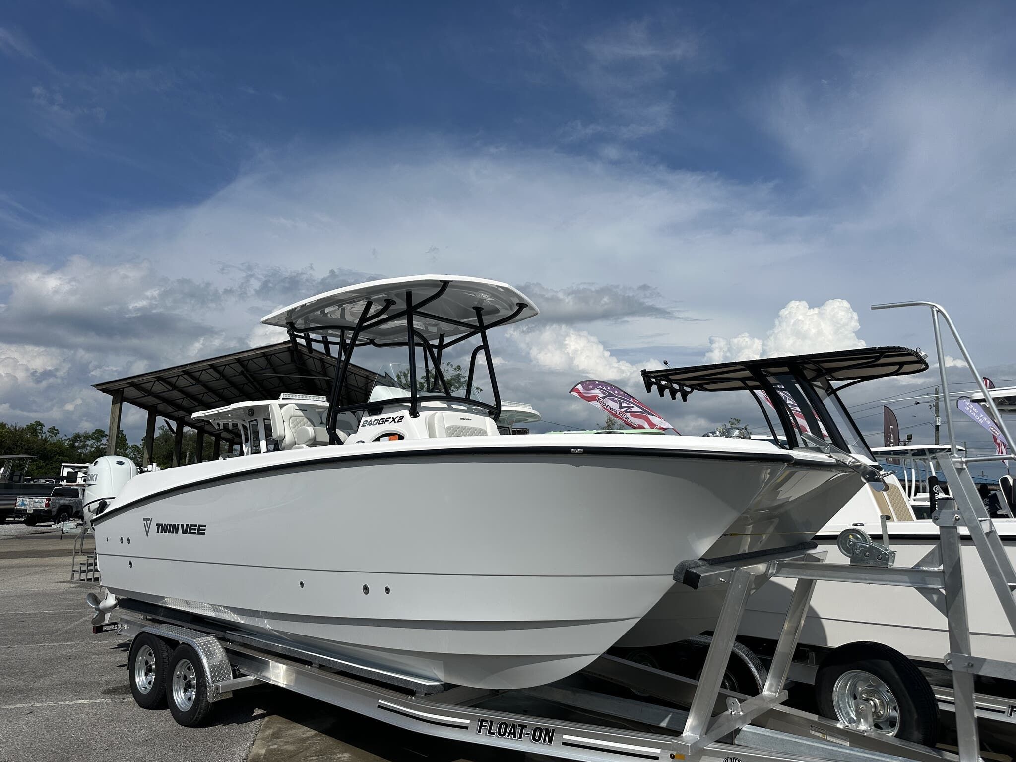 Twin Vee GFX 24GFX 2026 Twin Vee GFX 24GFX boat on trailer under cloudy sky.