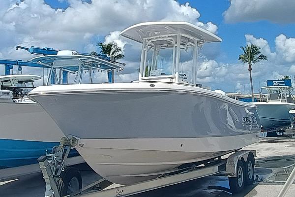 Robalo R230 Center Console 2025 Robalo R230 Center Console boat on trailer, parked under a blue sky with palm trees.