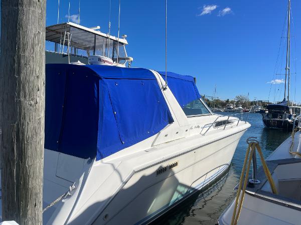 Sea Ray 370 Sundancer 1992 Sea Ray 370 Sundancer docked with blue canopy in marina.