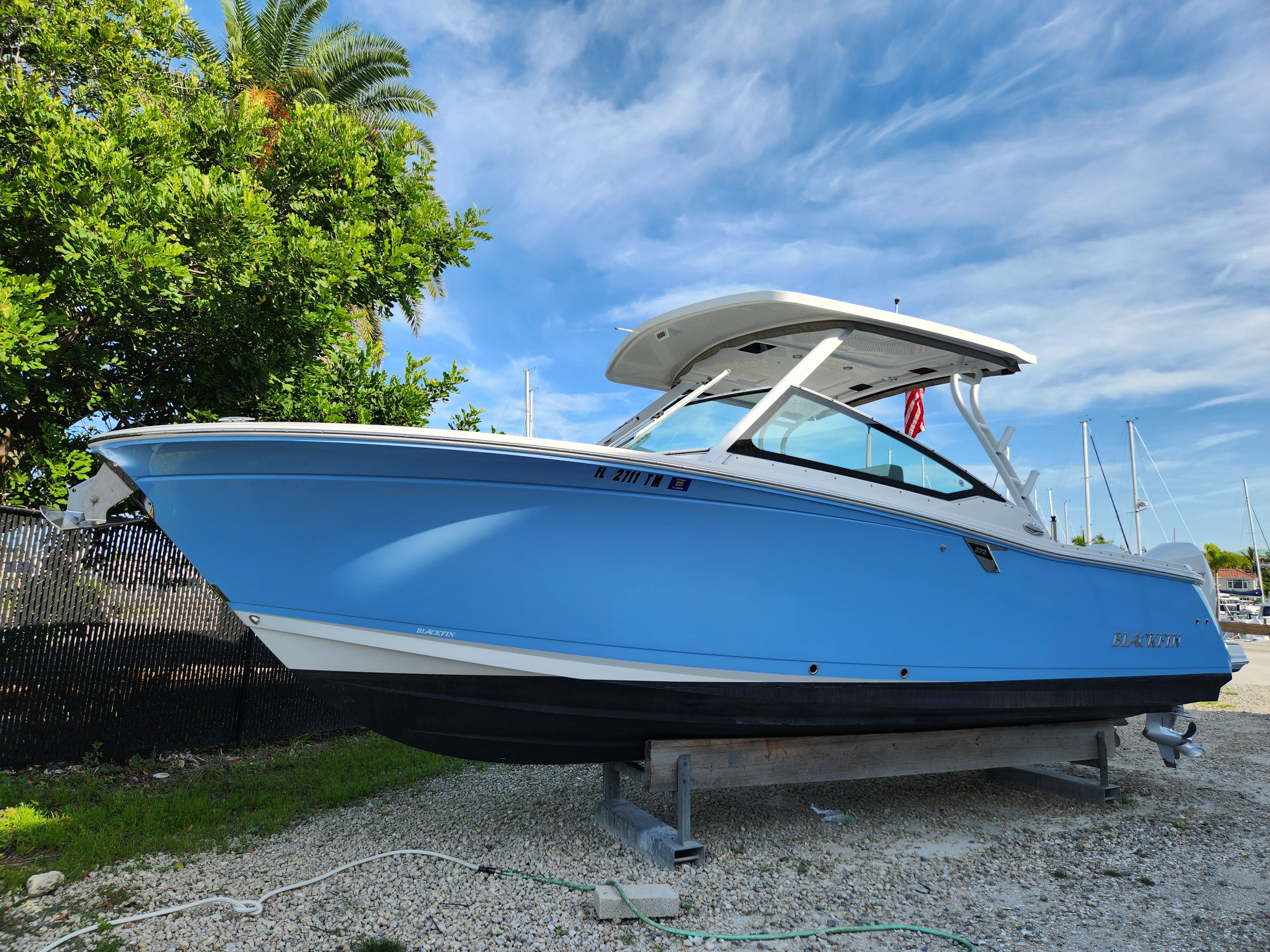 Blackfin 272 DC 2020 Blackfin 272 DC boat on display, vibrant blue hull, clear sky background.