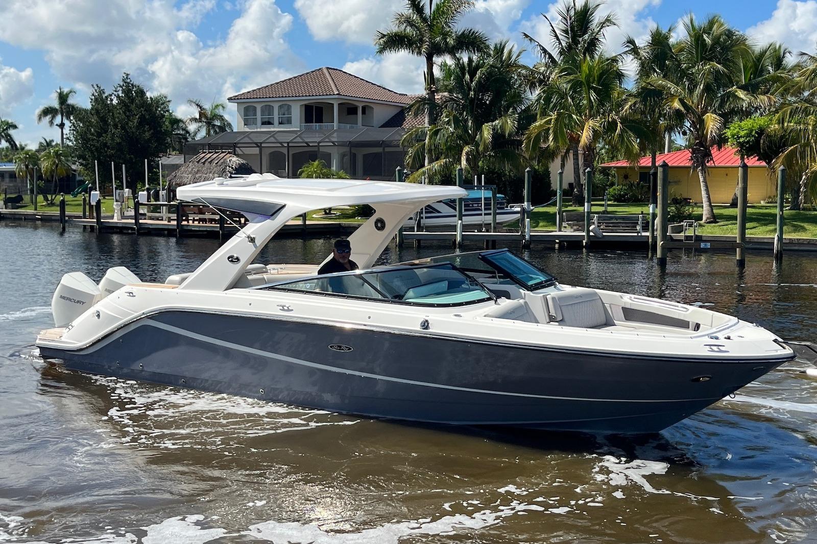 Sea Ray SLX 310 Outboard 2022 Sea Ray SLX 310 Outboard cruising on a sunny day near waterfront homes.