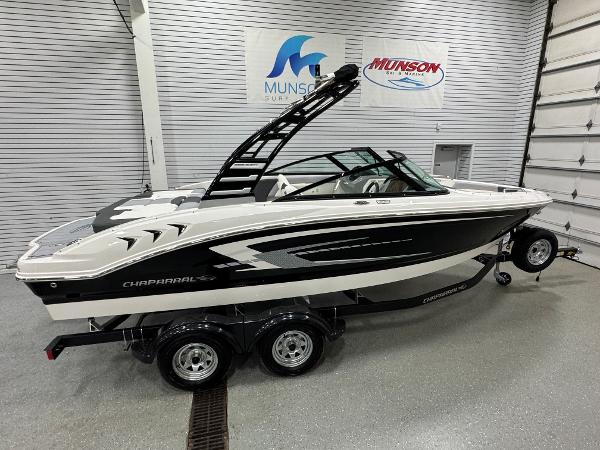 Chaparral 21 SSi 2025 Chaparral 21 SSi boat in showroom, black and white design, on trailer.