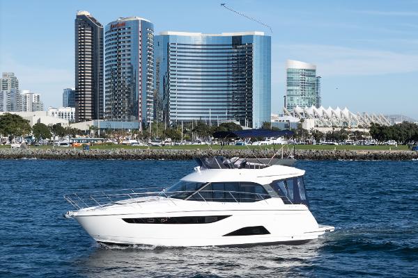 Bavaria R40 2024 Bavaria R40 yacht cruising in urban waterfront with modern skyscrapers in background.