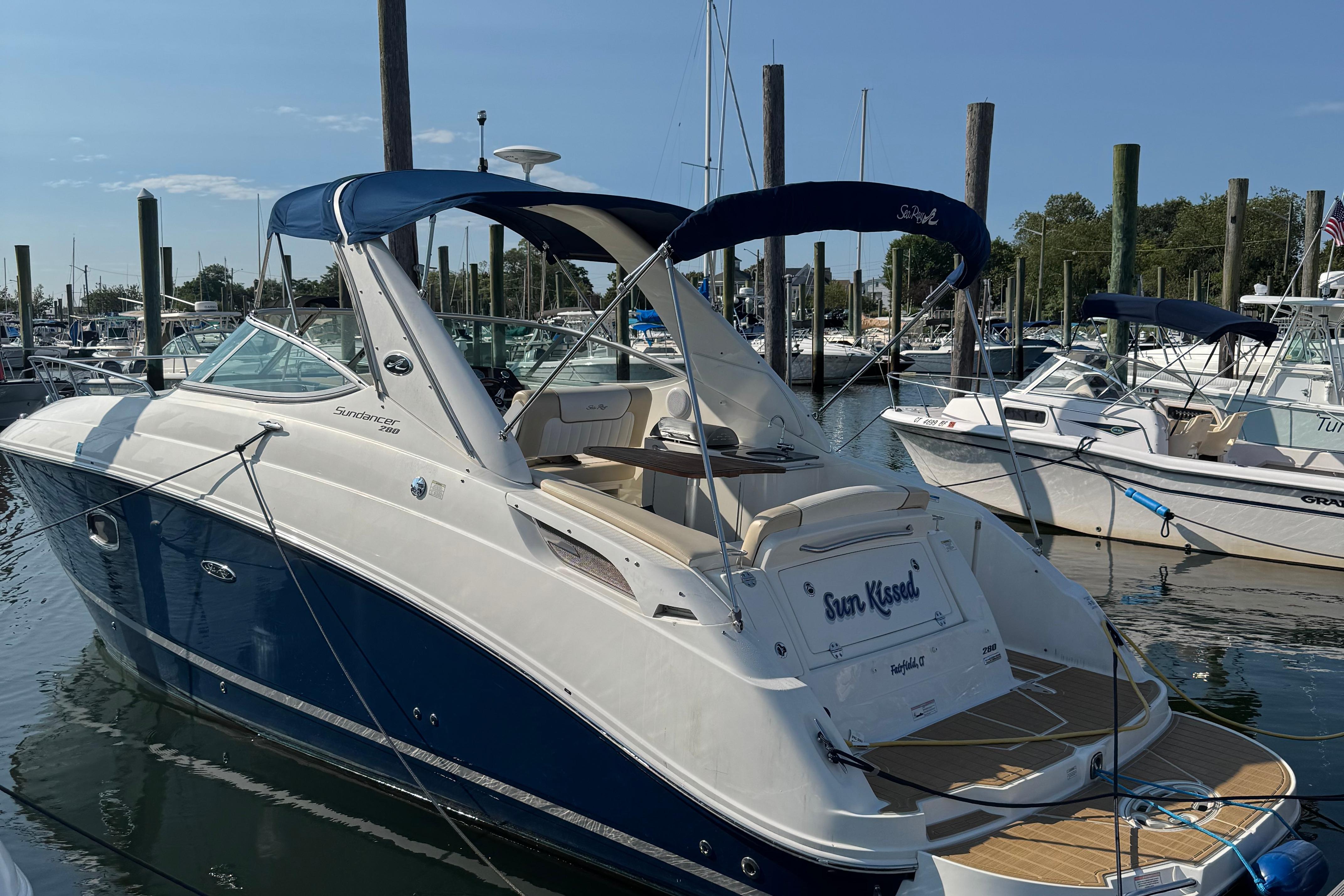 Sea Ray 280 Sundancer 2012 Sea Ray 280 Sundancer boat docked in marina, featuring sleek design and blue accents.