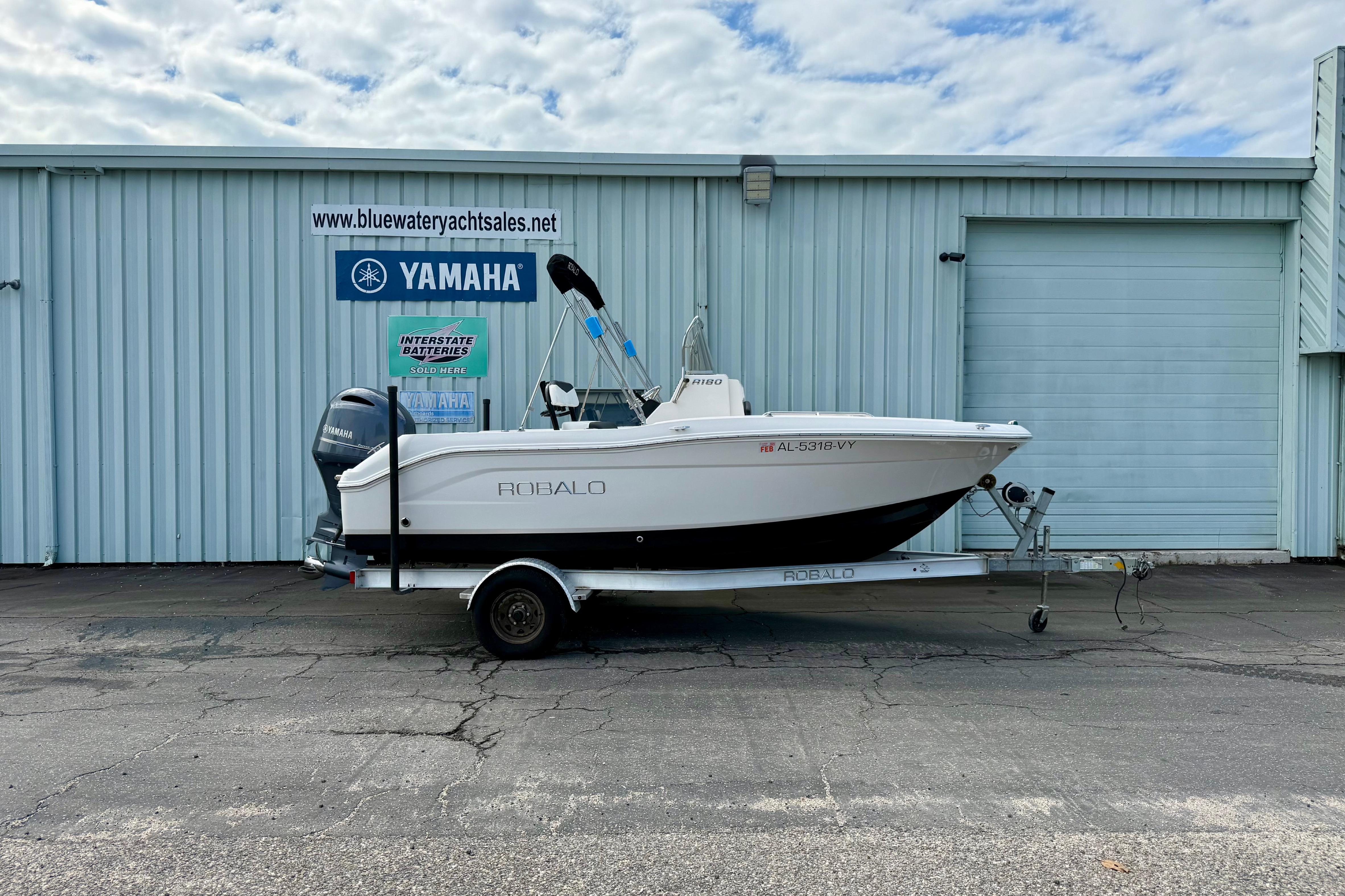 Robalo R180 Center Console 2018 Robalo R180 Center Console boat on trailer, parked outside dealership.