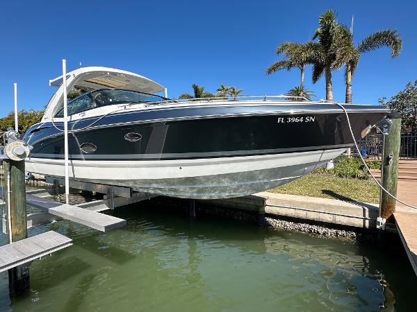 Formula 350 Crossover Bowrider OB 2020 Formula 350 Crossover Bowrider OB on lift, docked near palm trees.