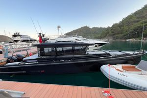 Axopar BRABUS SHADOW 900 XC SPECIFICATIONS 2023 Axopar BRABUS SHADOW 900 XC docked at marina, surrounded by lush greenery.