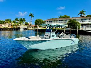 Sea Pro 245FLX Sandbar 2025 Sea Pro 245 FLX boat on calm water, with palm trees and houses in the background.