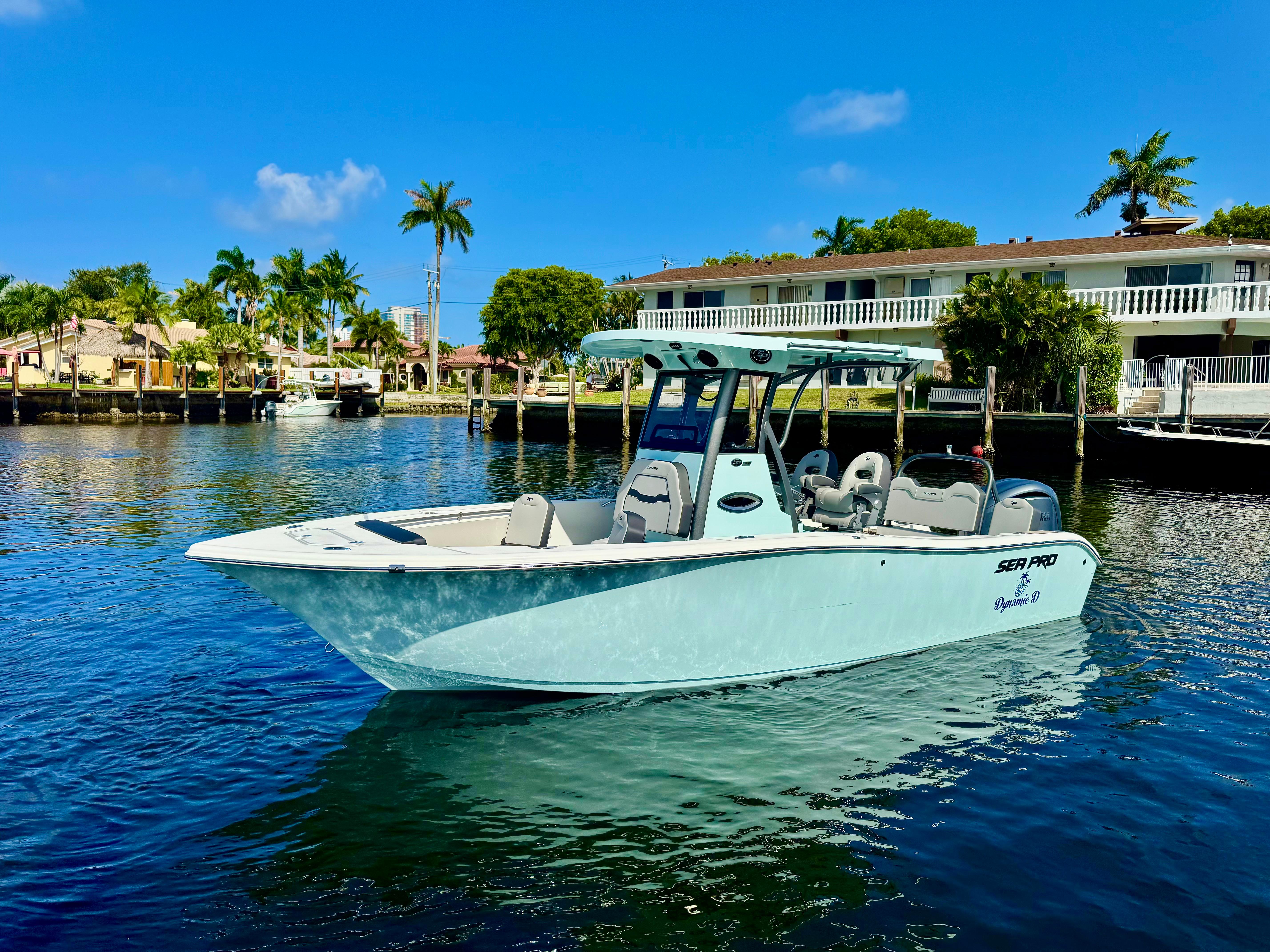 Sea Pro 245 FLX 2025 Sea Pro 245 FLX boat on calm water, with palm trees and houses in the background.