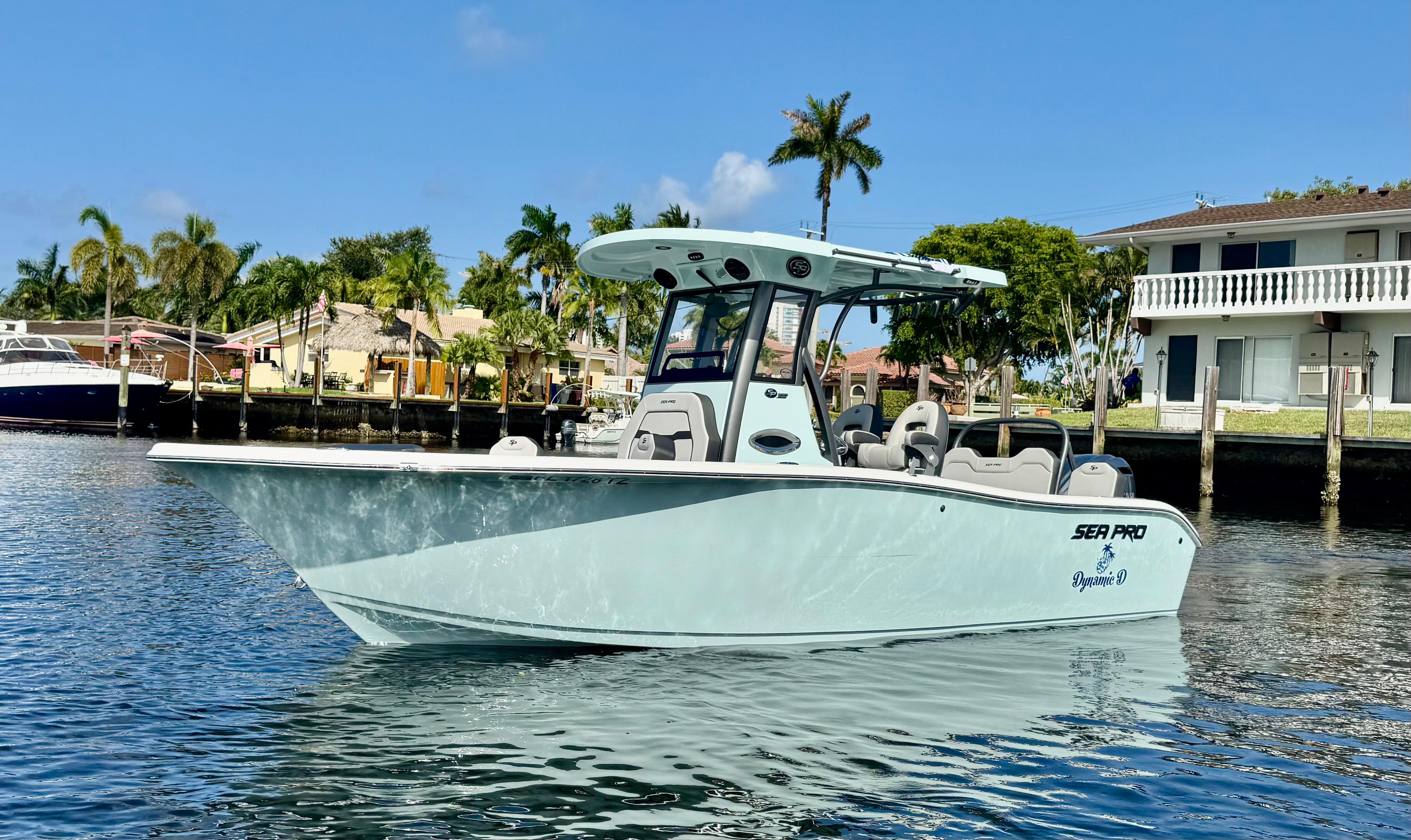 Sea Pro 245 FLX 2025 Sea Pro 245 FLX boat on calm water, with palm trees and houses in the background.