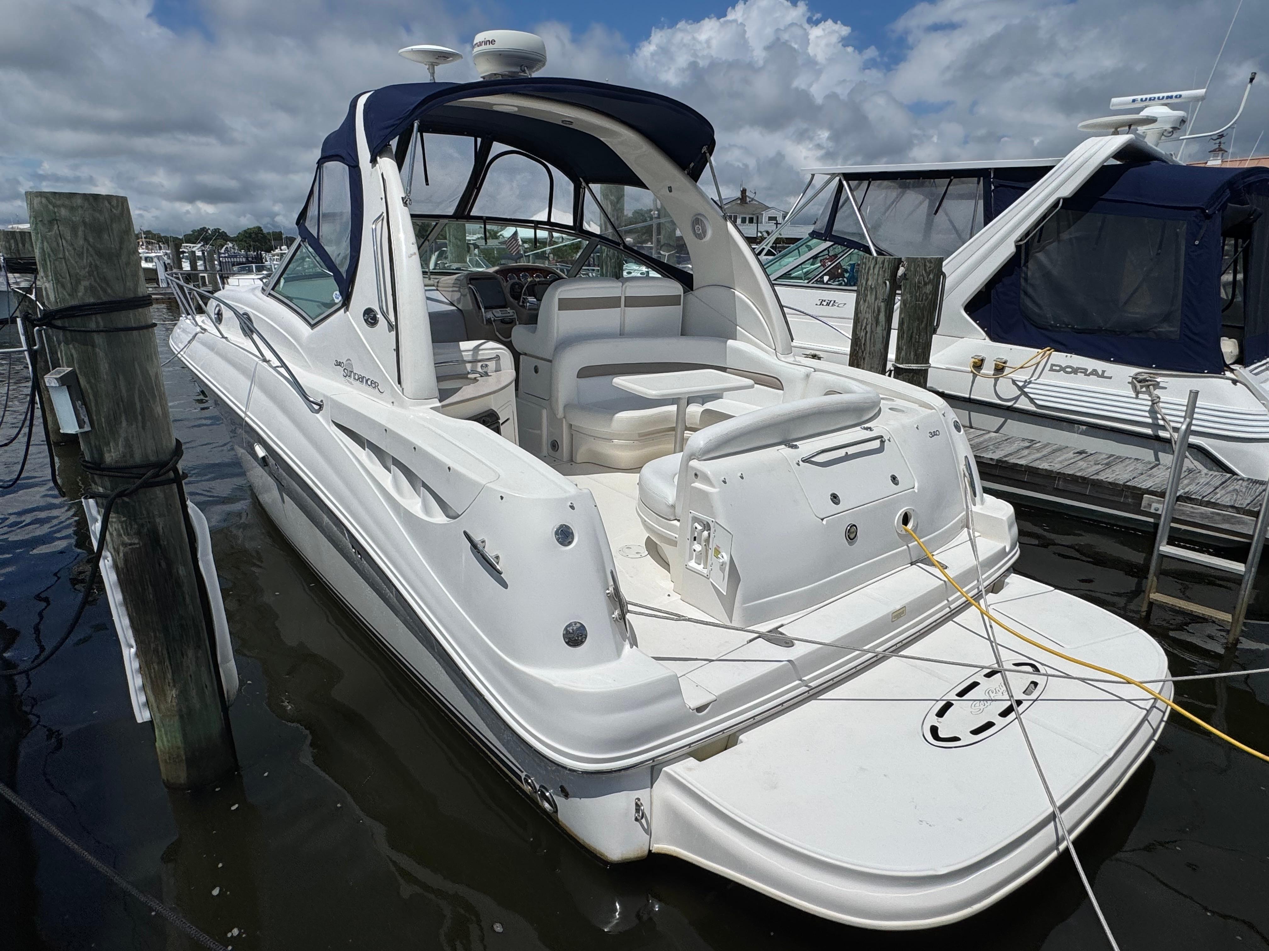 Sea Ray 320 Sundancer 2005 Sea Ray 320 Sundancer yacht docked at marina under cloudy sky.