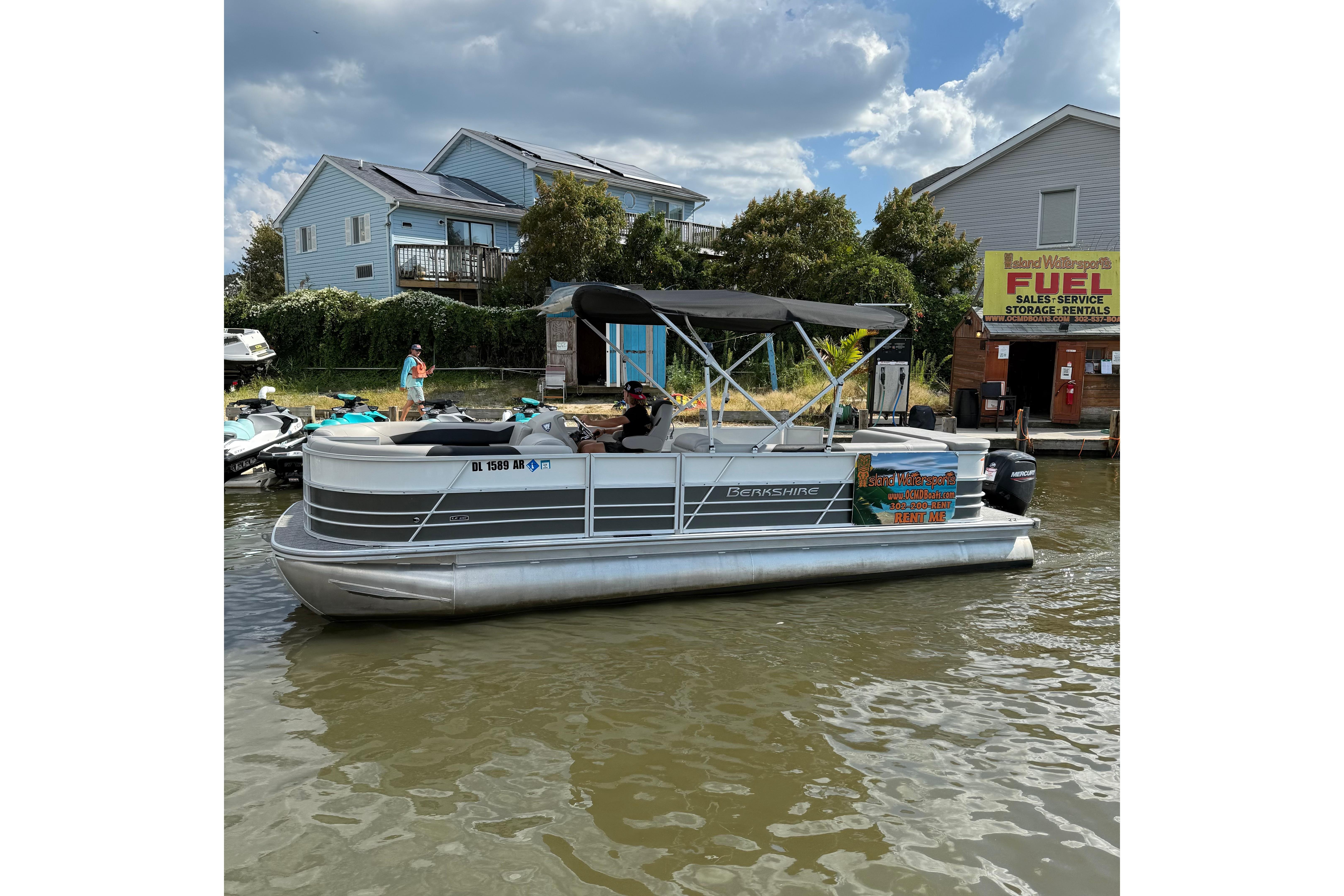 Berkshire 24CL 2.75 LE 2025 Berkshire 24CL 2.75 LE pontoon boat docked near waterfront buildings.