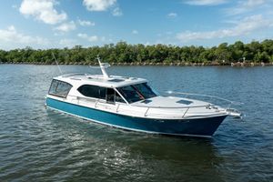 Hylas M49 2026 Hylas M49 yacht cruising on a serene river under a clear blue sky.